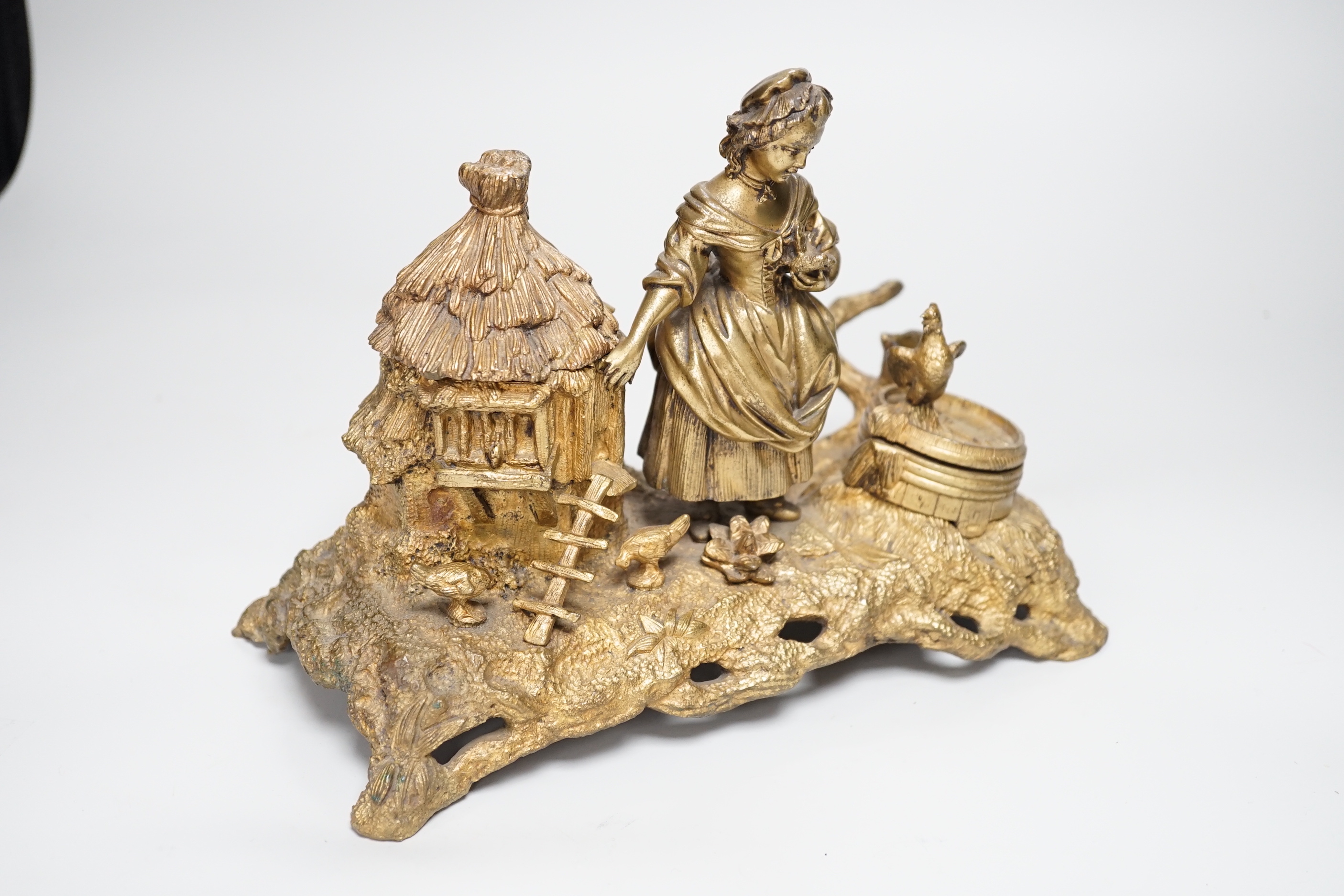 A 19th century gilt bronze inkwell decorated with a farmyard scene and country maiden, 18cm high